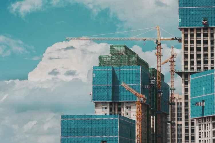 High-rise construction site with tower cranes and building facade work, representing commercial construction progress monitoring